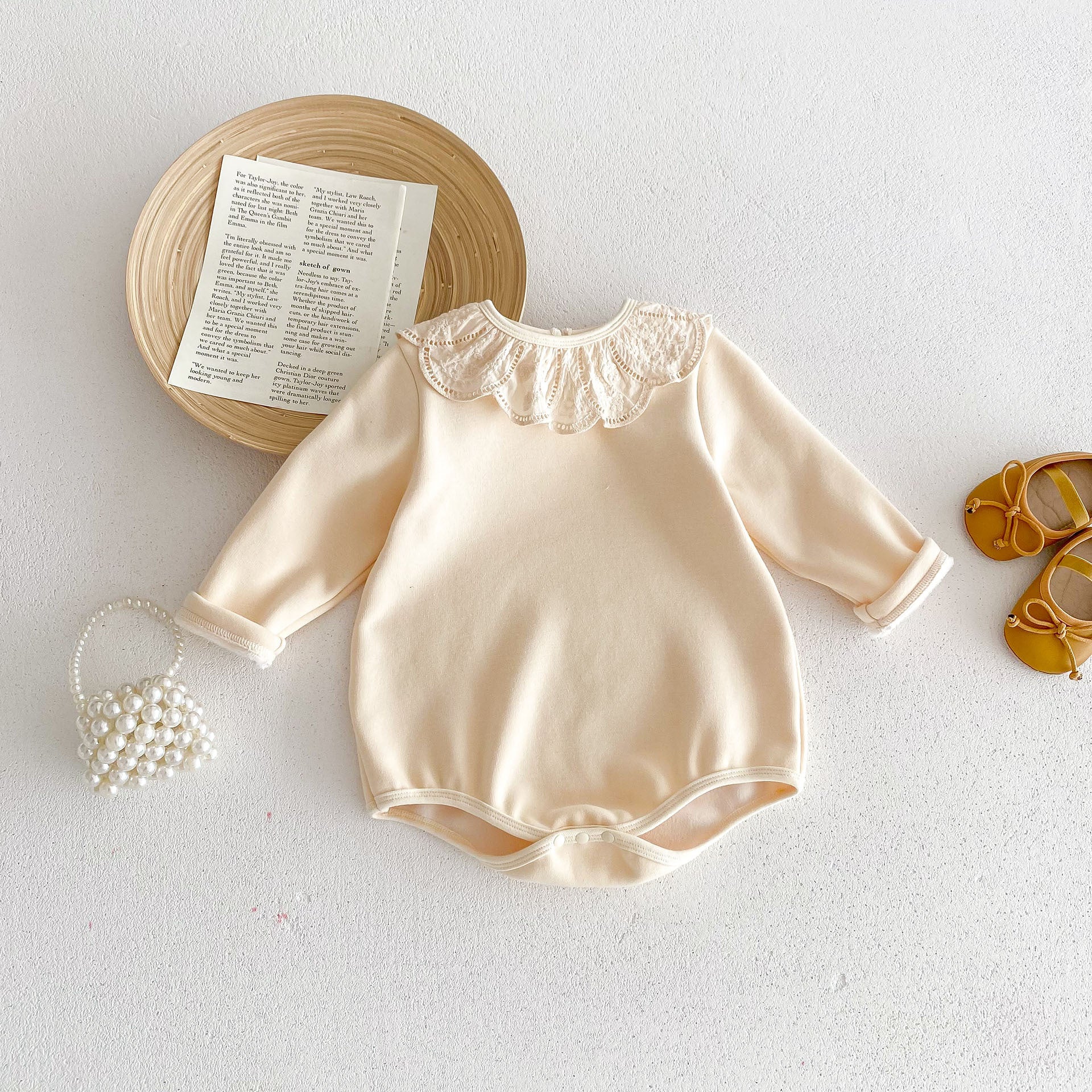 Newborn baby girl wearing a solid beige crew neck long sleeve dress with lace collar, showcasing comfort and style.