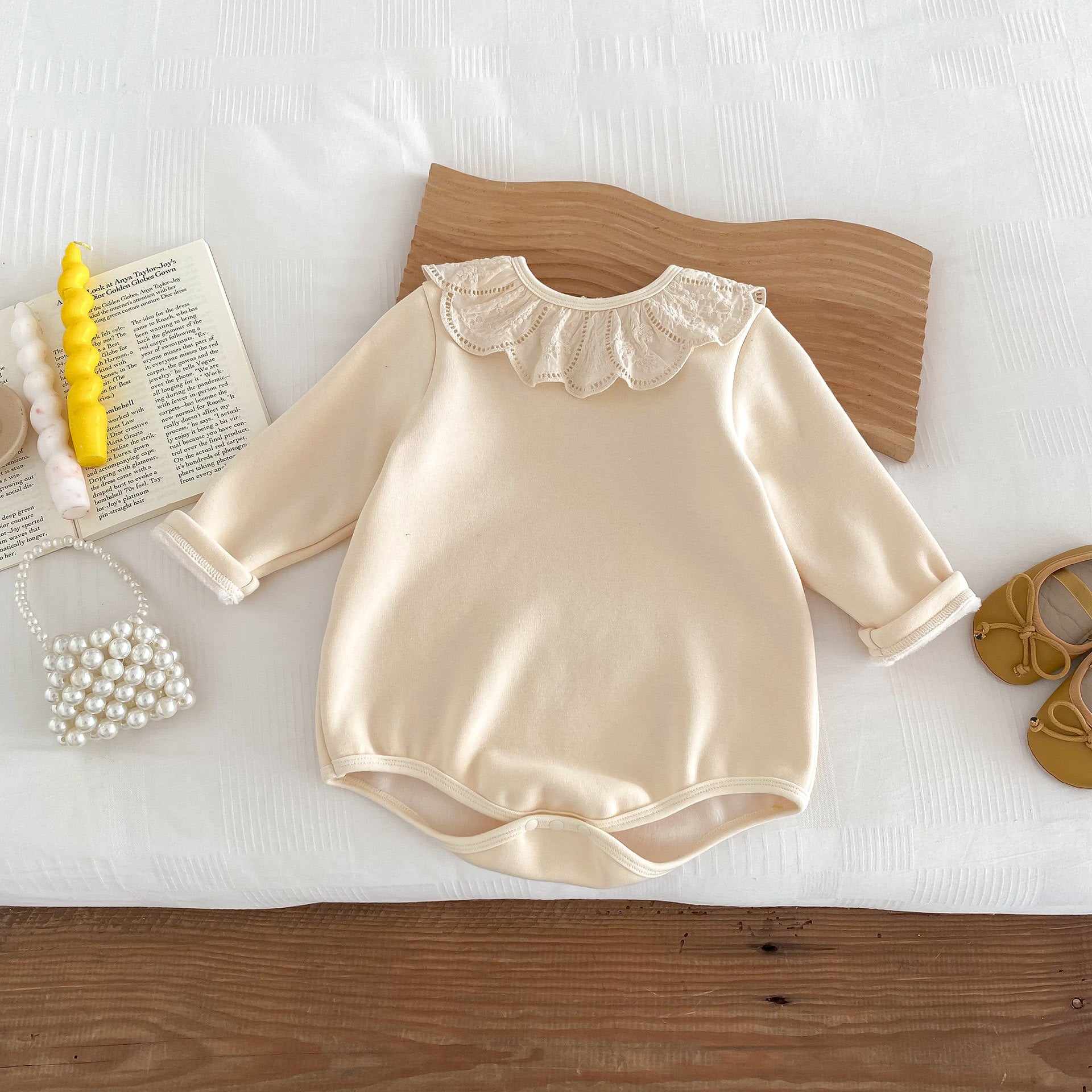 Newborn baby girl wearing a solid beige crew neck long sleeve dress with lace collar, showcasing comfort and style.