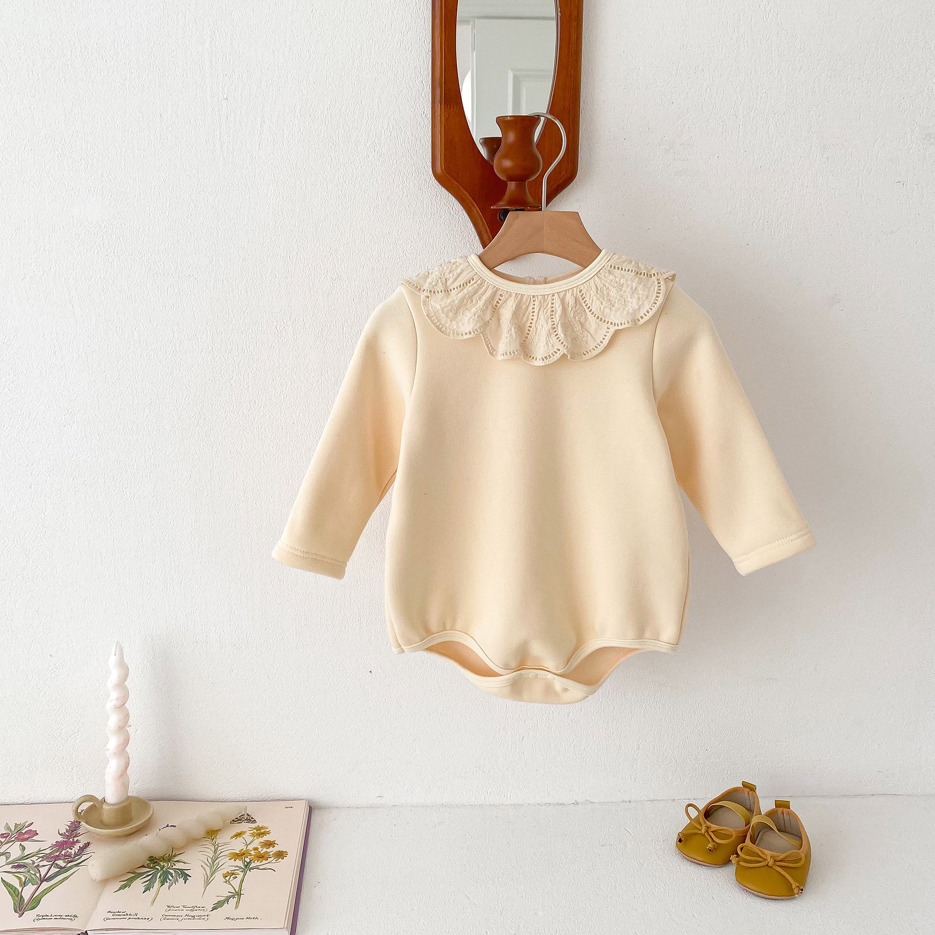 Newborn baby girl wearing a solid beige crew neck long sleeve dress with lace collar, showcasing comfort and style.