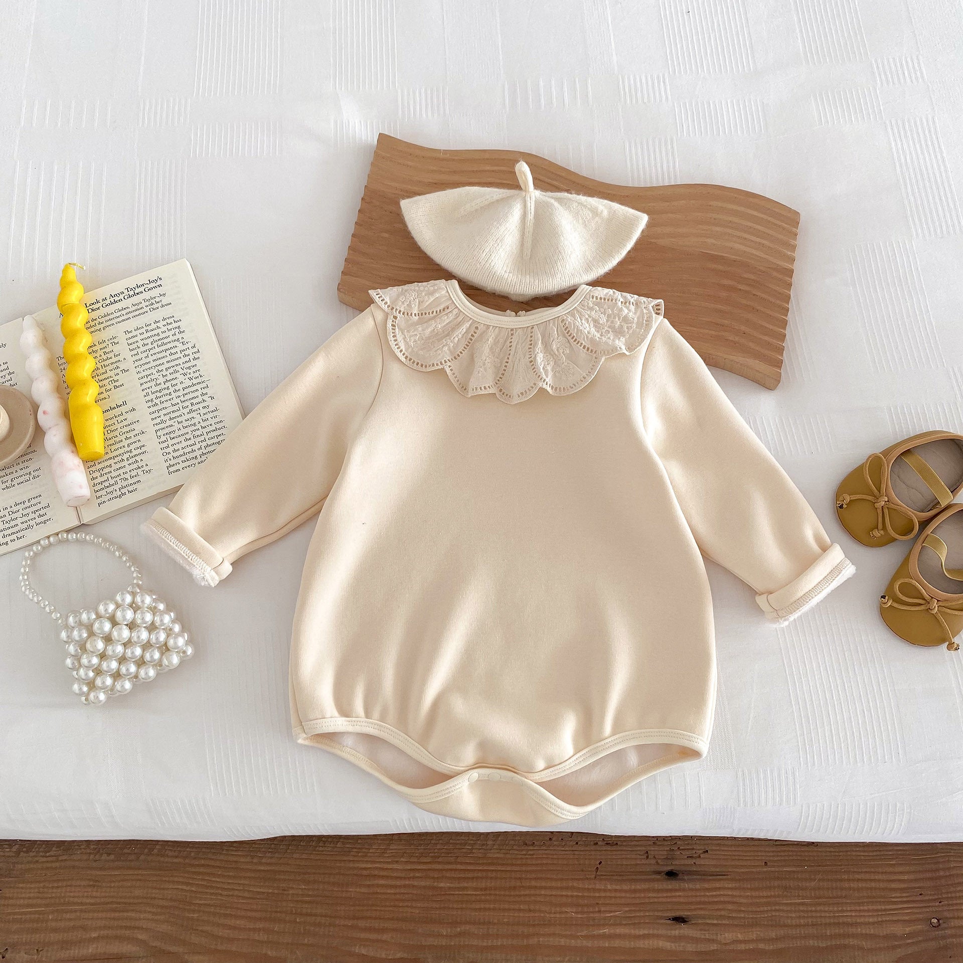 Newborn baby girl wearing a solid beige crew neck long sleeve dress with lace collar, showcasing comfort and style.