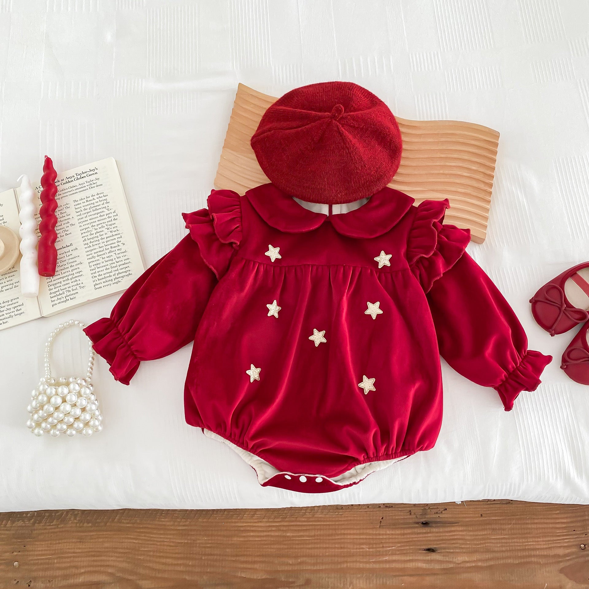 Newborn baby girl wearing a red Peter Pan collar dress with long ruffle sleeves, showcasing a stylish and comfortable design.