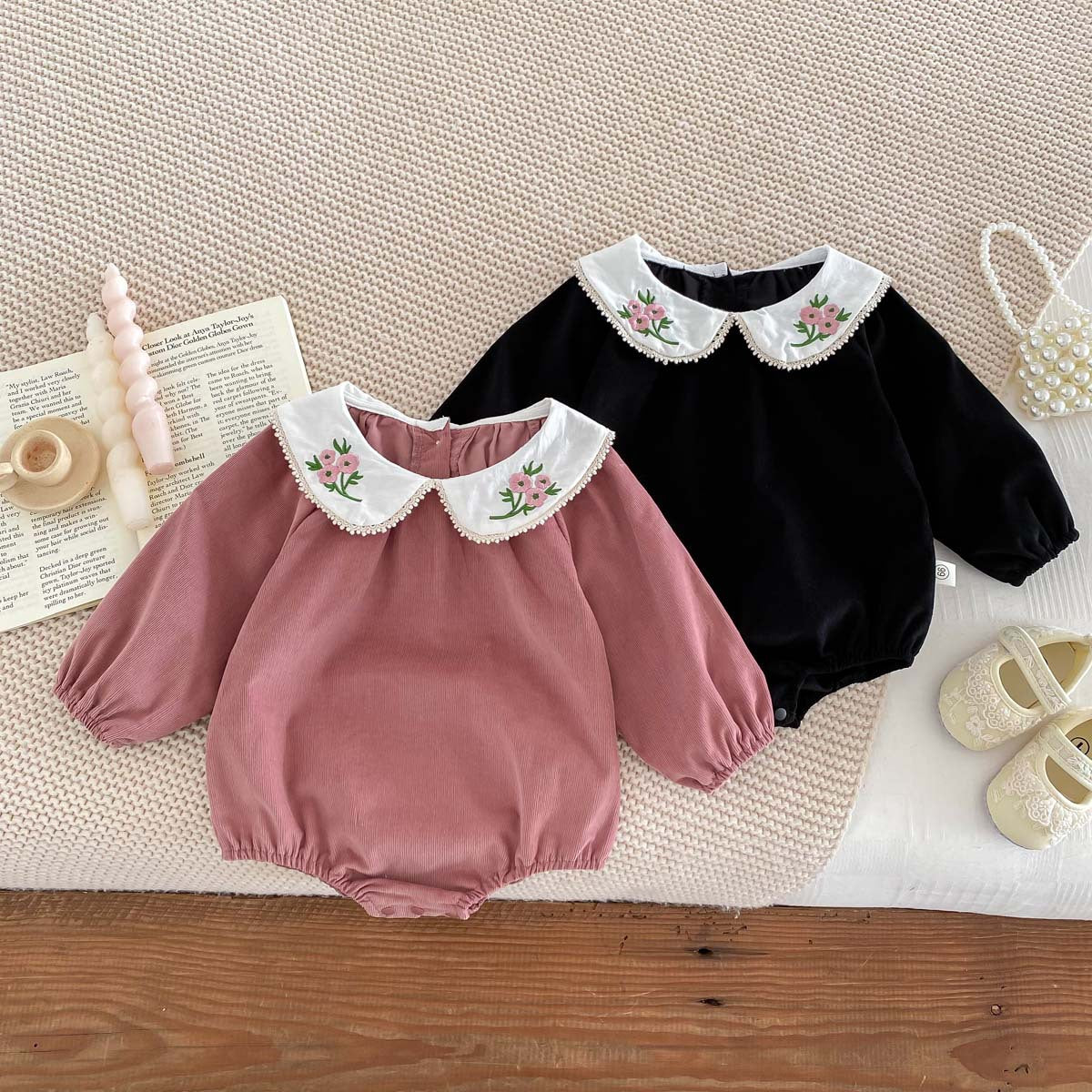 Newborn baby girl wearing a stylish Peter Pan floral collar long sleeves outfit in black and pink, showcasing a charming design.