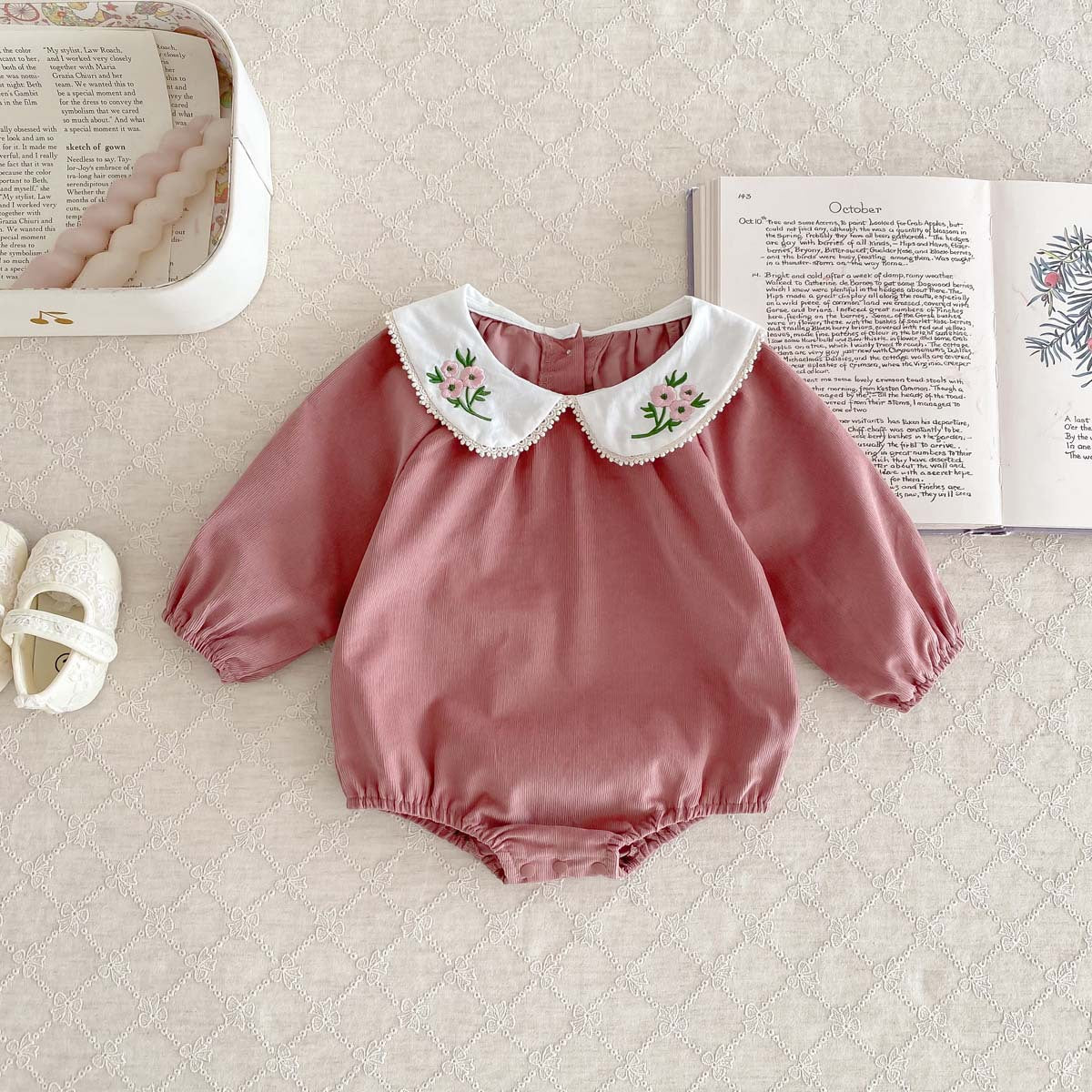 Newborn baby girl wearing a stylish Peter Pan floral collar long sleeves outfit in black and pink, showcasing a charming design.