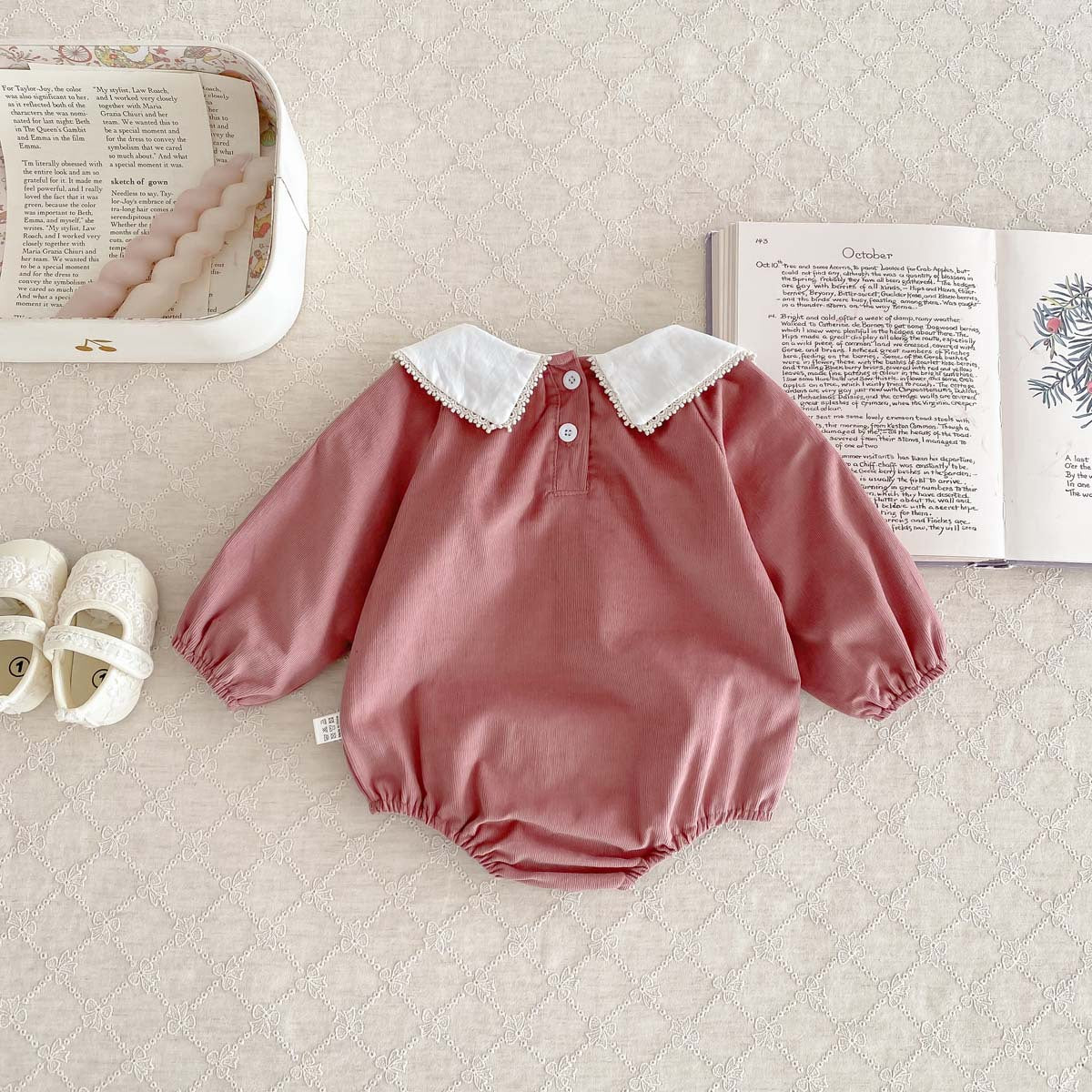 Newborn baby girl wearing a stylish Peter Pan floral collar long sleeves outfit in black and pink, showcasing a charming design.