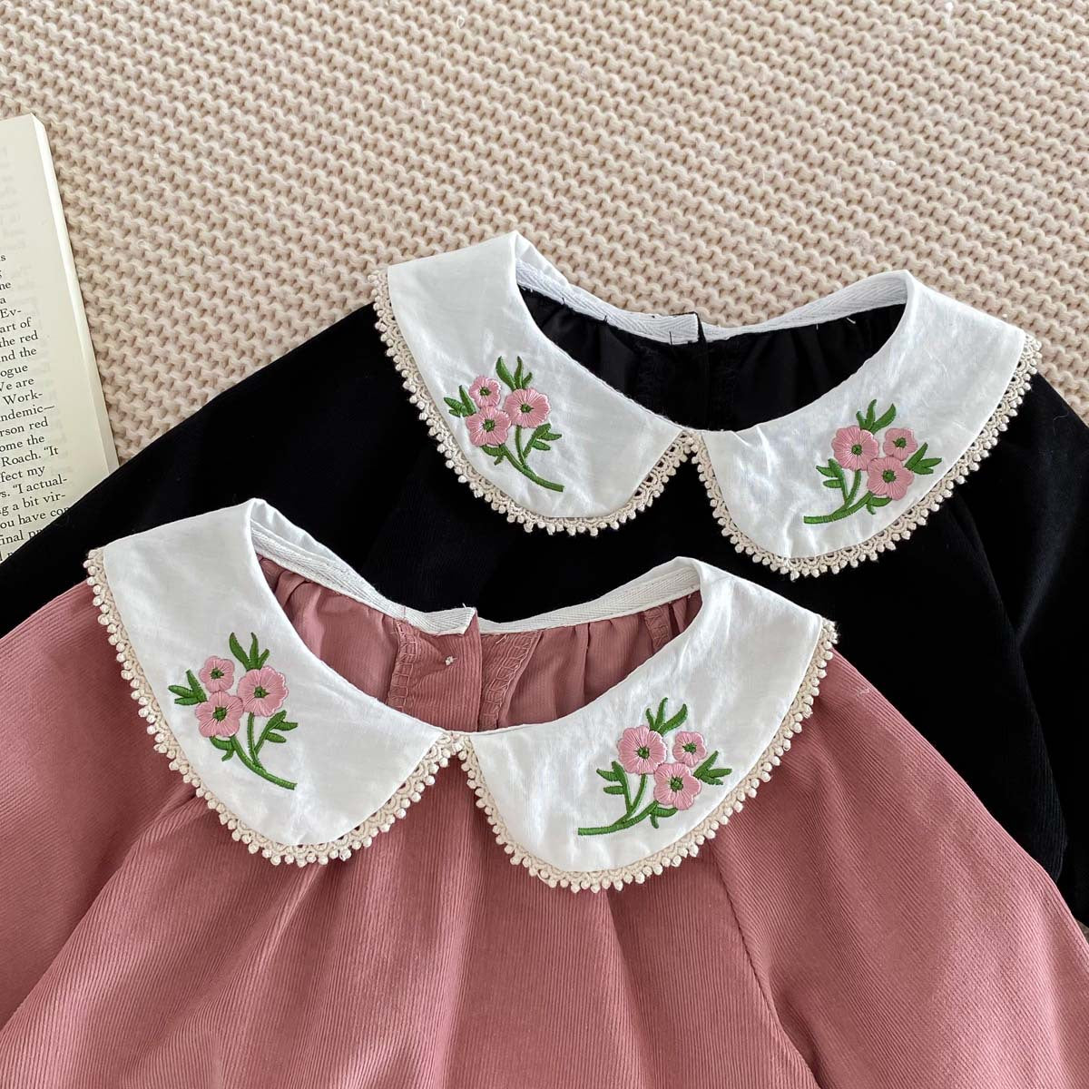 Newborn baby girl wearing a stylish Peter Pan floral collar long sleeves outfit in black and pink, showcasing a charming design.