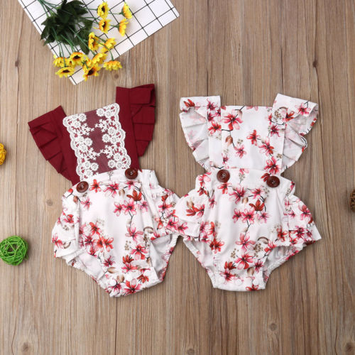 Floral baby outfits on wood.