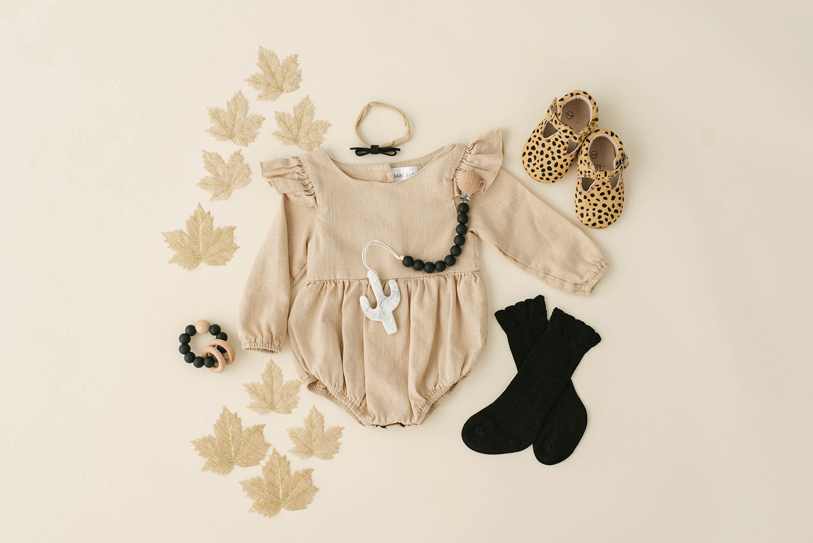 Oatmeal Linen Flutter Sleeve Romper for babies, featuring soft linen fabric and diaper snaps.