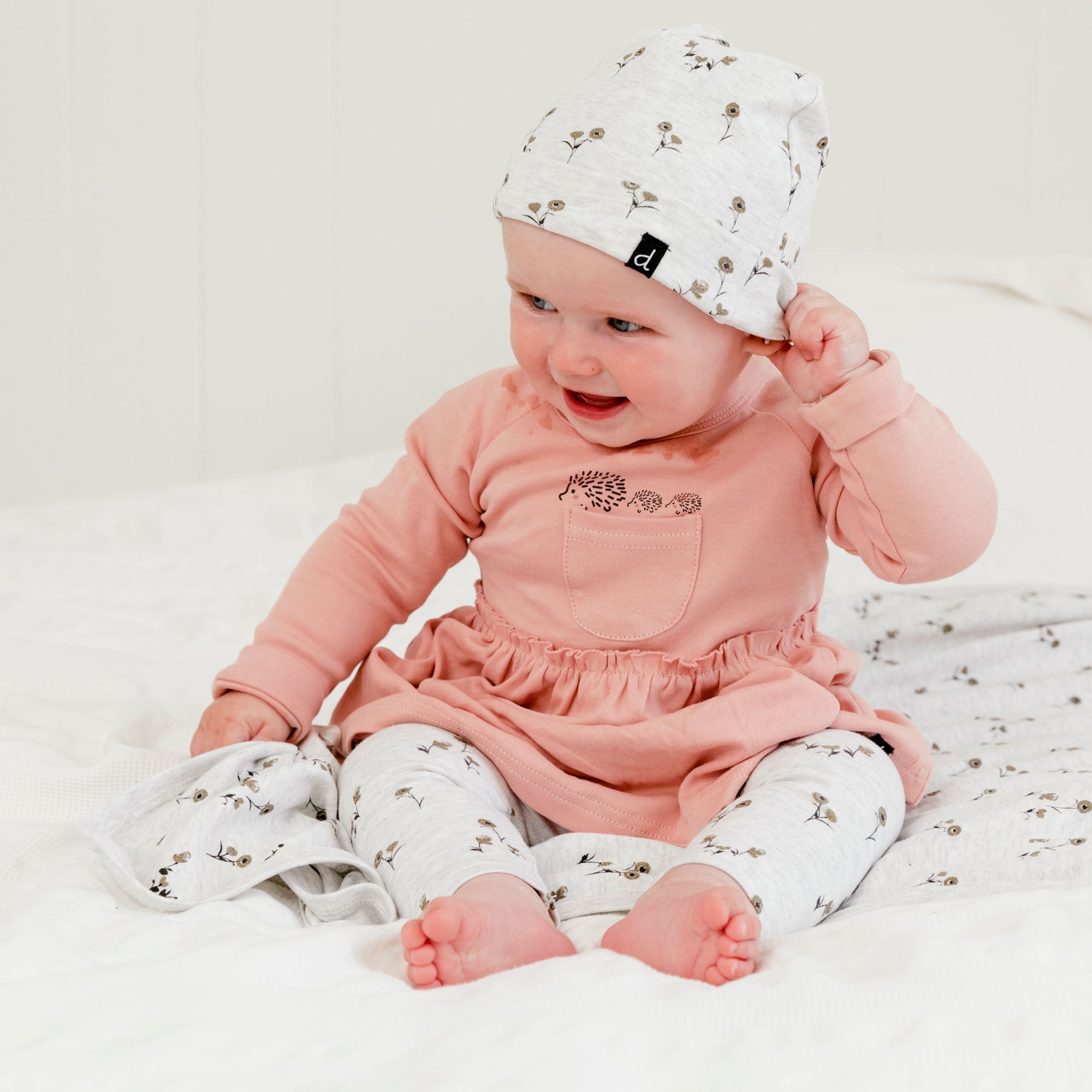 Organic cotton hat and bib set featuring small flower print and ruffle trim, perfect for babies.