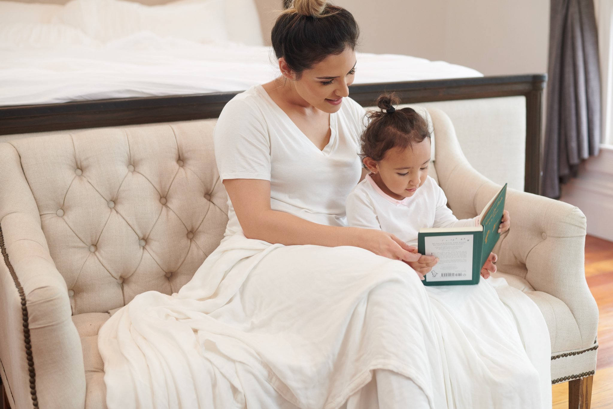 Pristine White Oversized King Luxury Bamboo Muslin Bed Blanket displayed on a bed, showcasing its soft texture and elegant design.