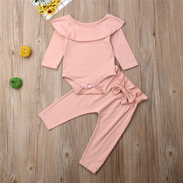 Peach baby outfit on floor.