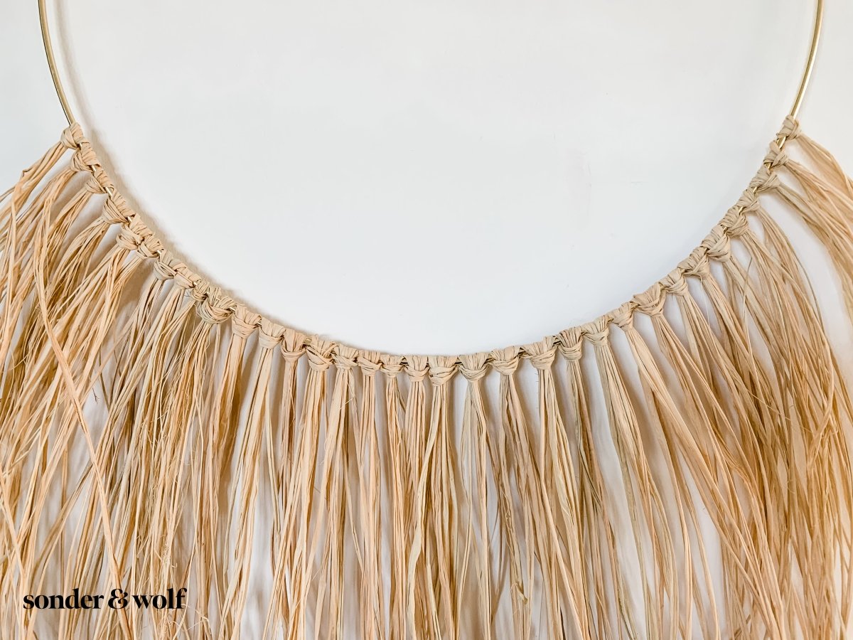 A beautifully crafted Raffia Wall Hanging showcasing natural fibers in a bohemian style, perfect for home decor.