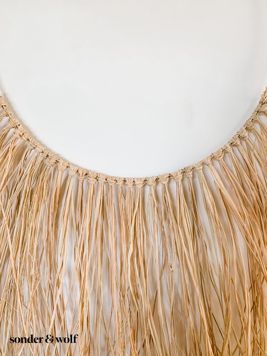 A beautifully crafted Raffia Wall Hanging showcasing natural fibers in a bohemian style, perfect for home decor.