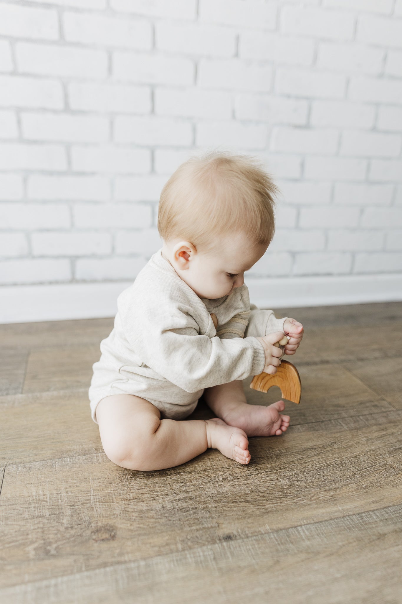 A soft and lightweight Rainbow Baby Bodysuit in grey and green, perfect for infants.