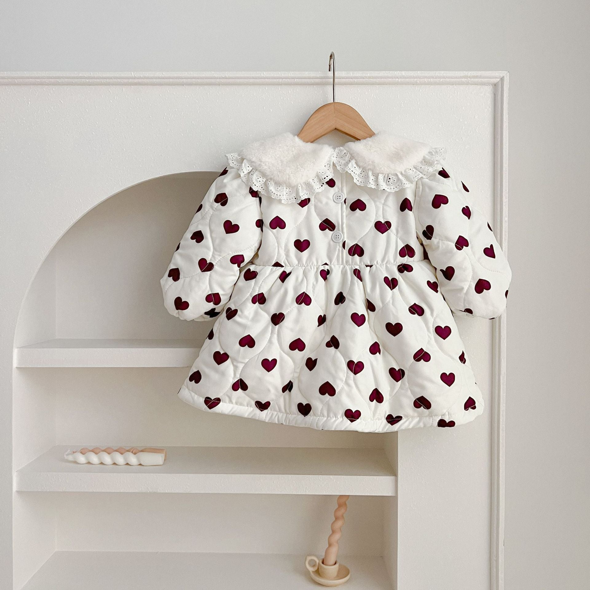 A beautiful long sleeve dress featuring a red heart pattern and a Peter Pan lace collar, perfect for young girls.