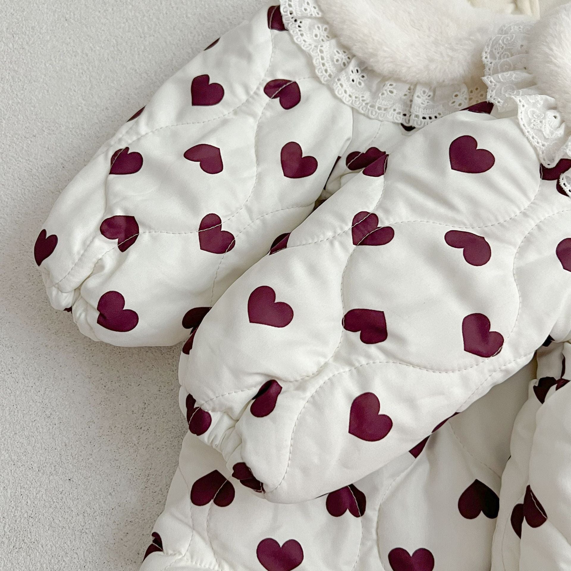 A beautiful long sleeve dress featuring a red heart pattern and a Peter Pan lace collar, perfect for young girls.