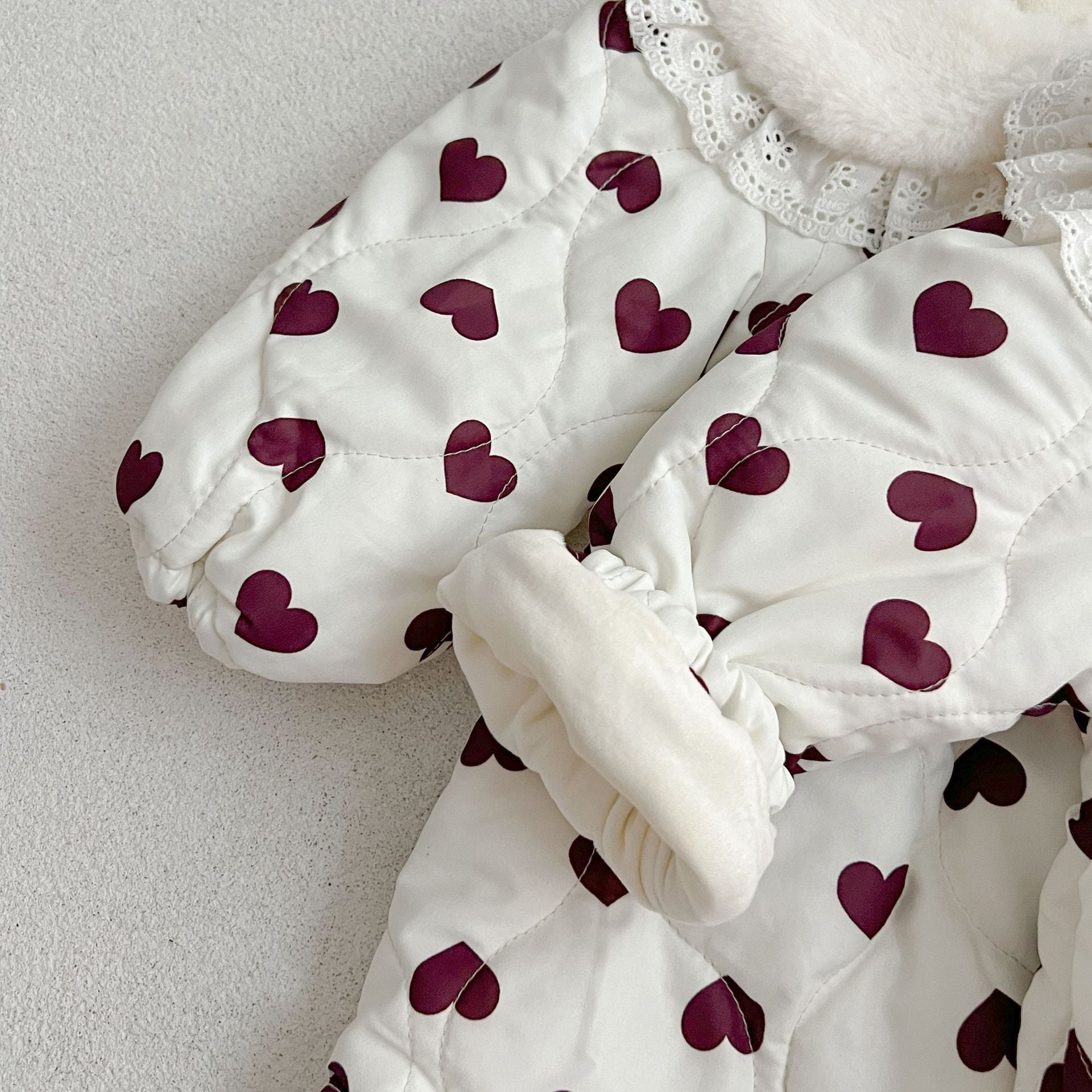 A beautiful long sleeve dress featuring a red heart pattern and a Peter Pan lace collar, perfect for young girls.