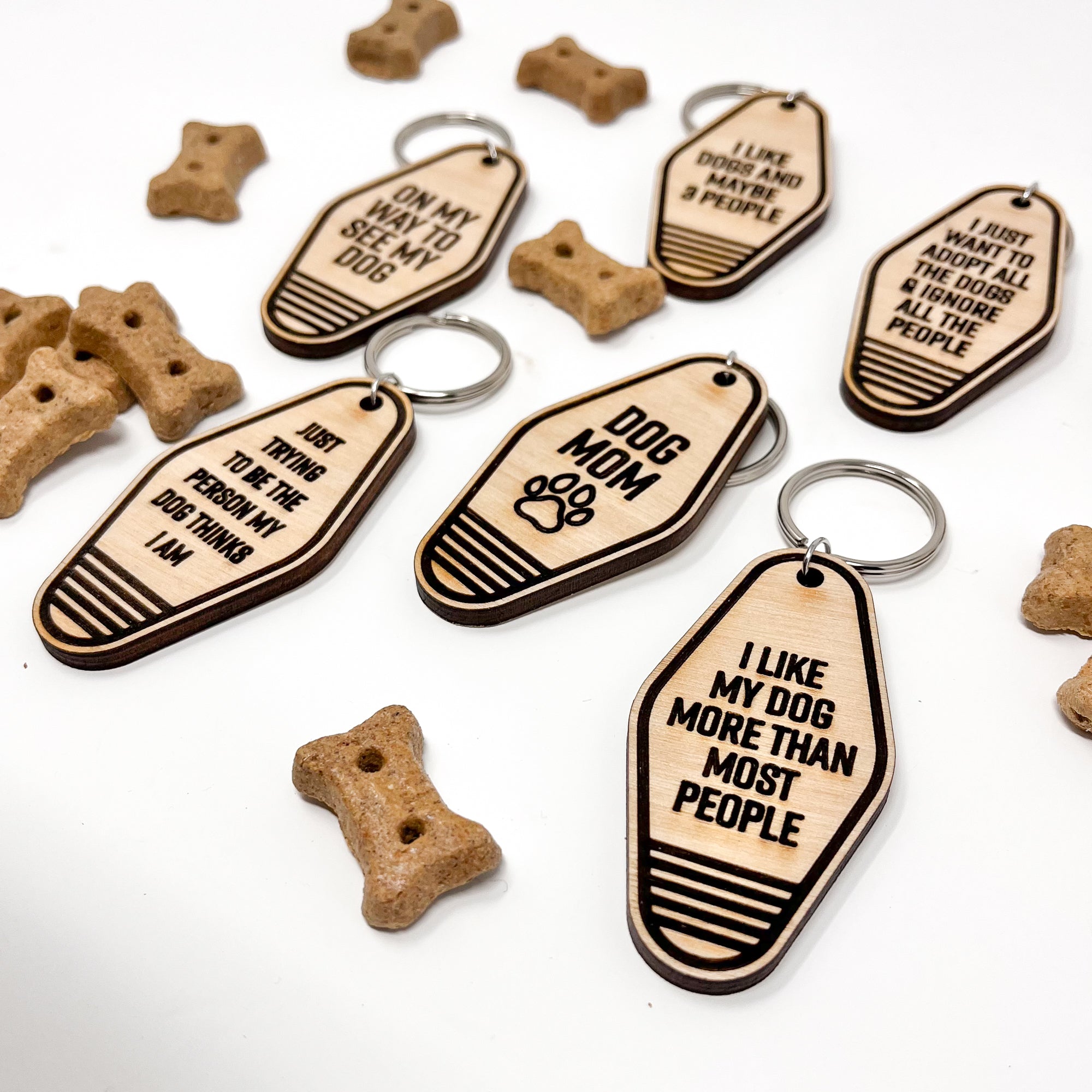 A collection of unique retro dog keychains made from natural wood, featuring laser-engraved designs and heartfelt messages for dog lovers.