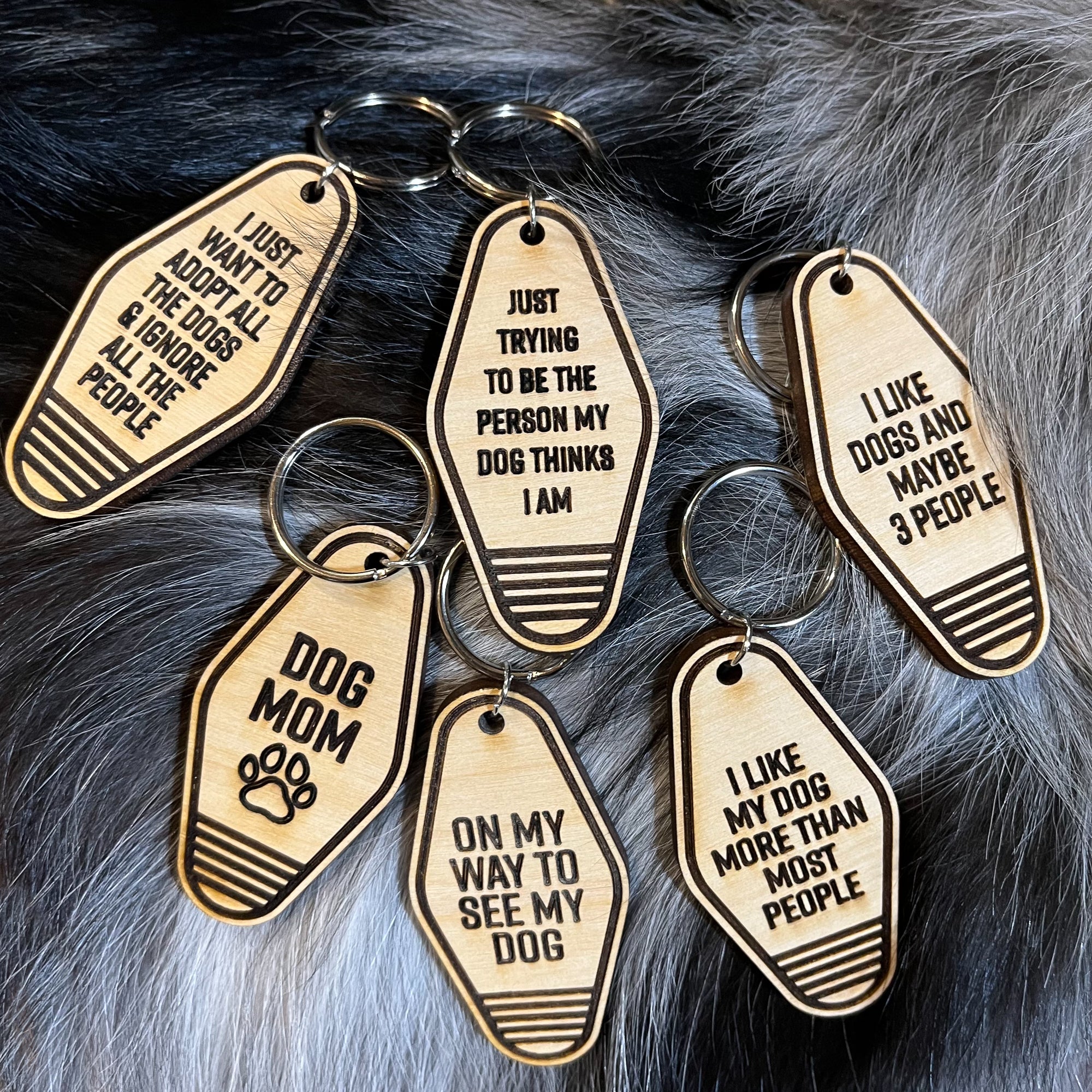 A collection of unique retro dog keychains made from natural wood, featuring laser-engraved designs and heartfelt messages for dog lovers.