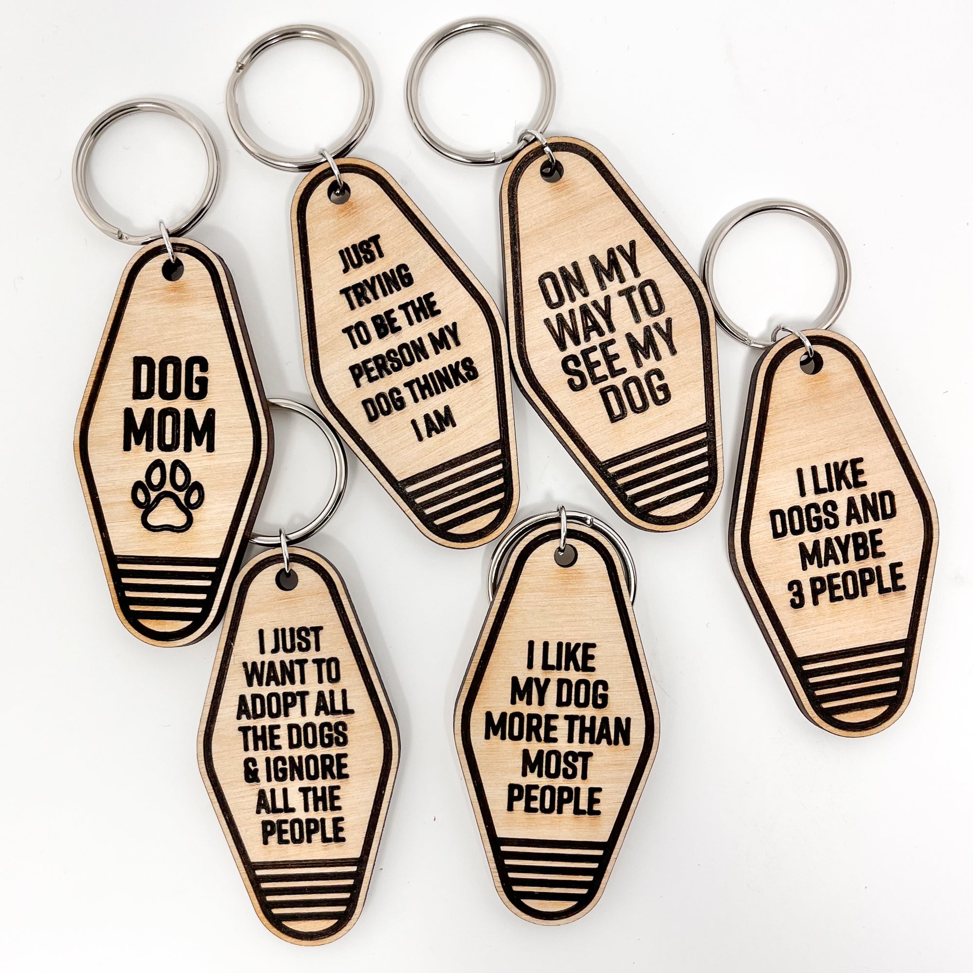 A collection of unique retro dog keychains made from natural wood, featuring laser-engraved designs and heartfelt messages for dog lovers.