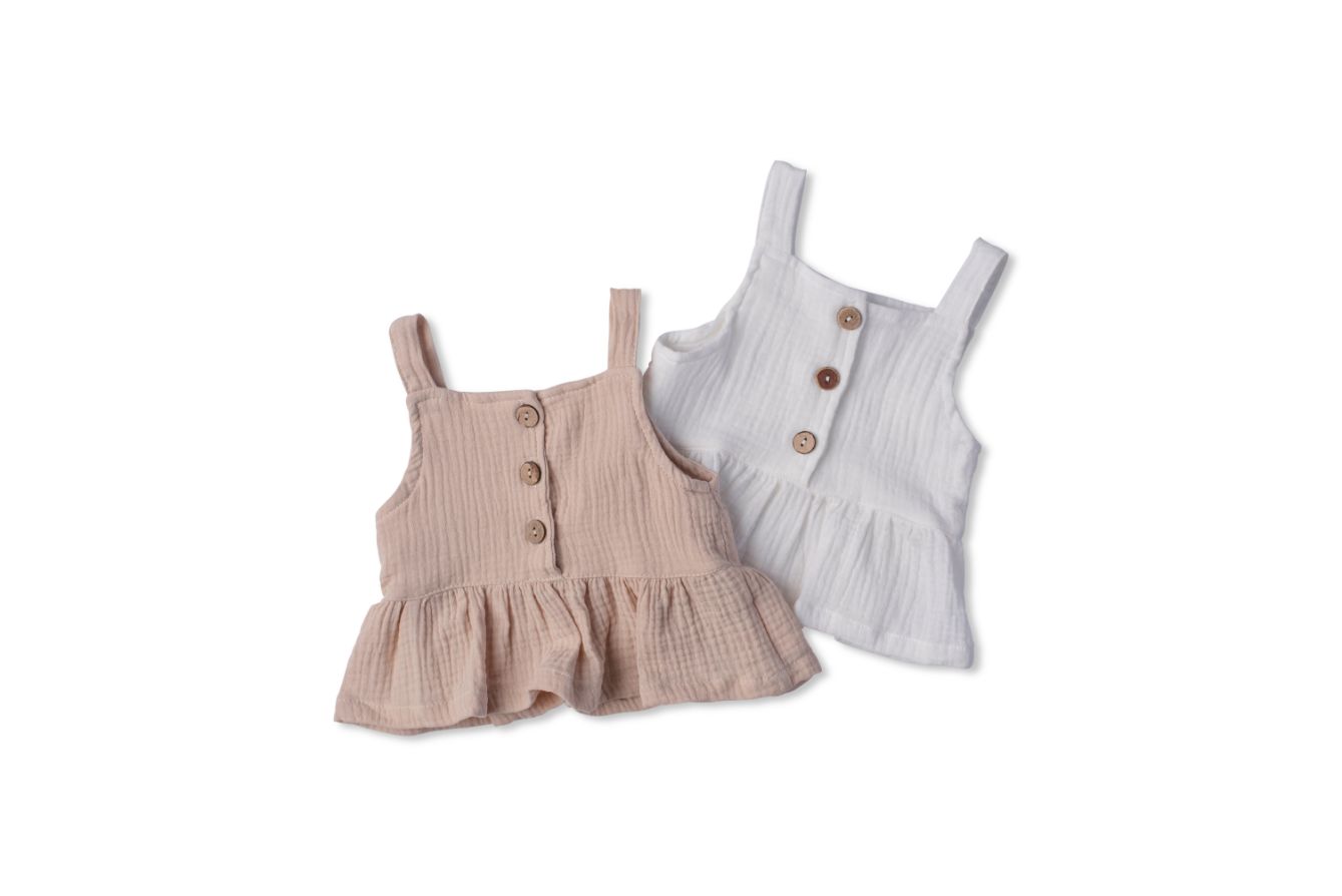 A soft cotton ruffle tank top in beige and white, perfect for layering and comfortable wear for children.