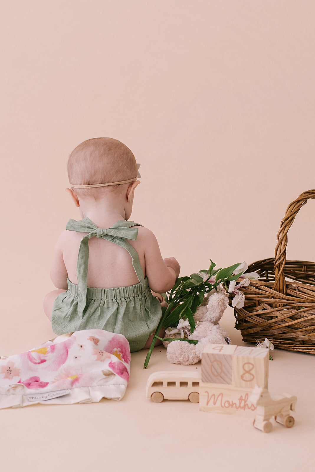 A stylish Sage Halter Romper made from soft linen, featuring diaper snaps and a chic halter design, perfect for babies.