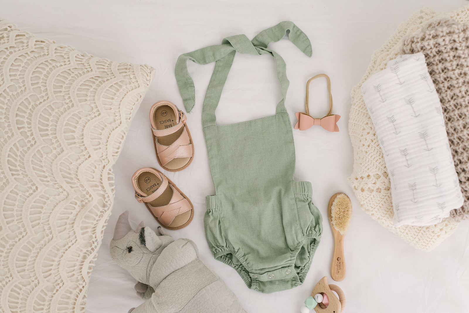 A stylish Sage Halter Romper made from soft linen, featuring diaper snaps and a chic halter design, perfect for babies.