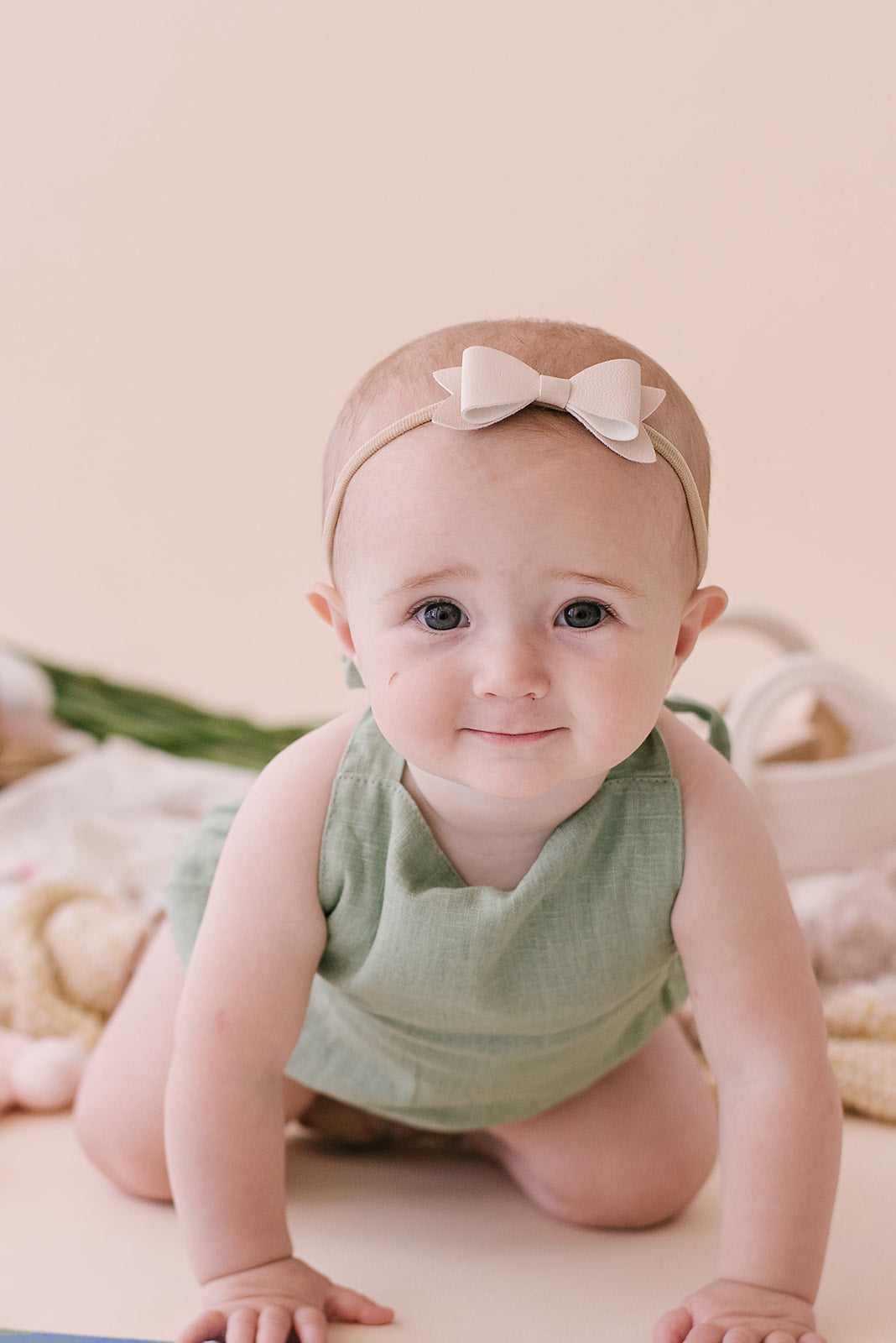 A stylish Sage Halter Romper made from soft linen, featuring diaper snaps and a chic halter design, perfect for babies.