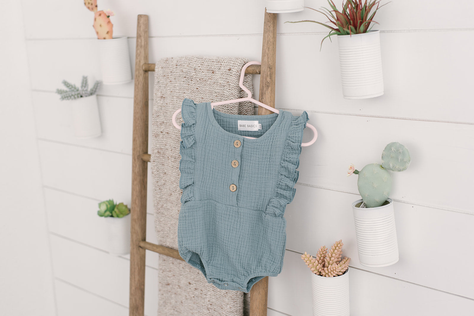 A stylish Seafoam Summer Romper made from soft linen, featuring diaper snaps and a classic design for babies.