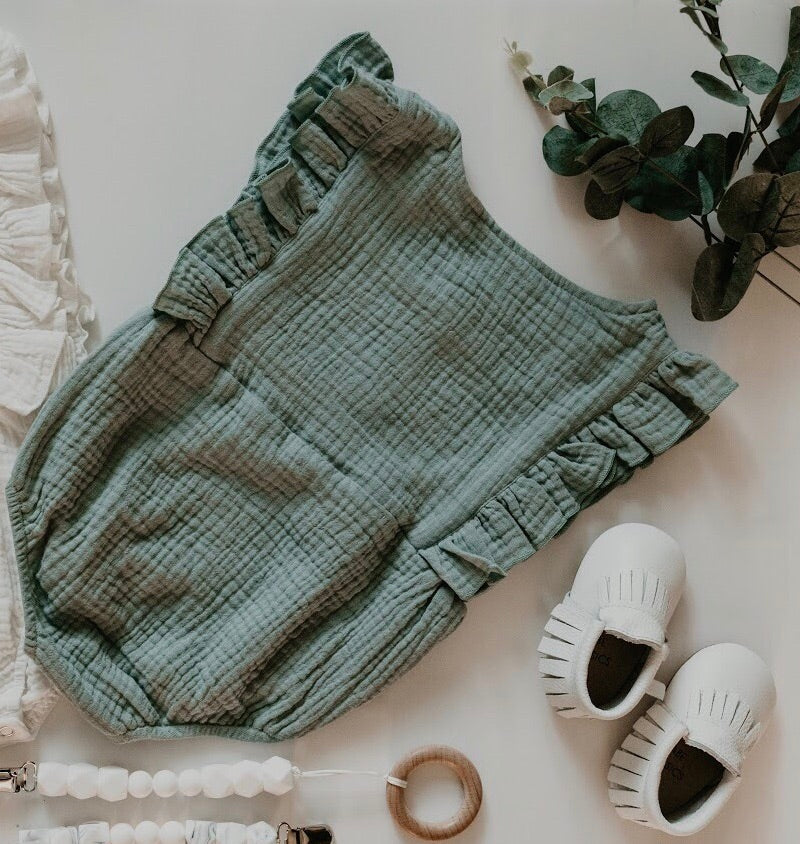 A stylish Seafoam Summer Romper made from soft linen, featuring diaper snaps and a classic design for babies.