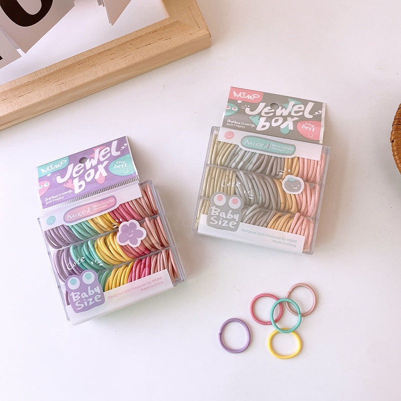 A colorful assortment of small seamless hairbands in black, green, yellow, grey, and orange, showcasing their high elasticity and suitability for young girls.