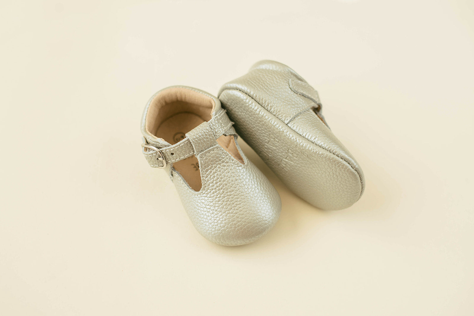 Soft-Sole Leather Mary Jane Moccasins in silver, featuring a t-strap buckle and soft leather soles for comfort.