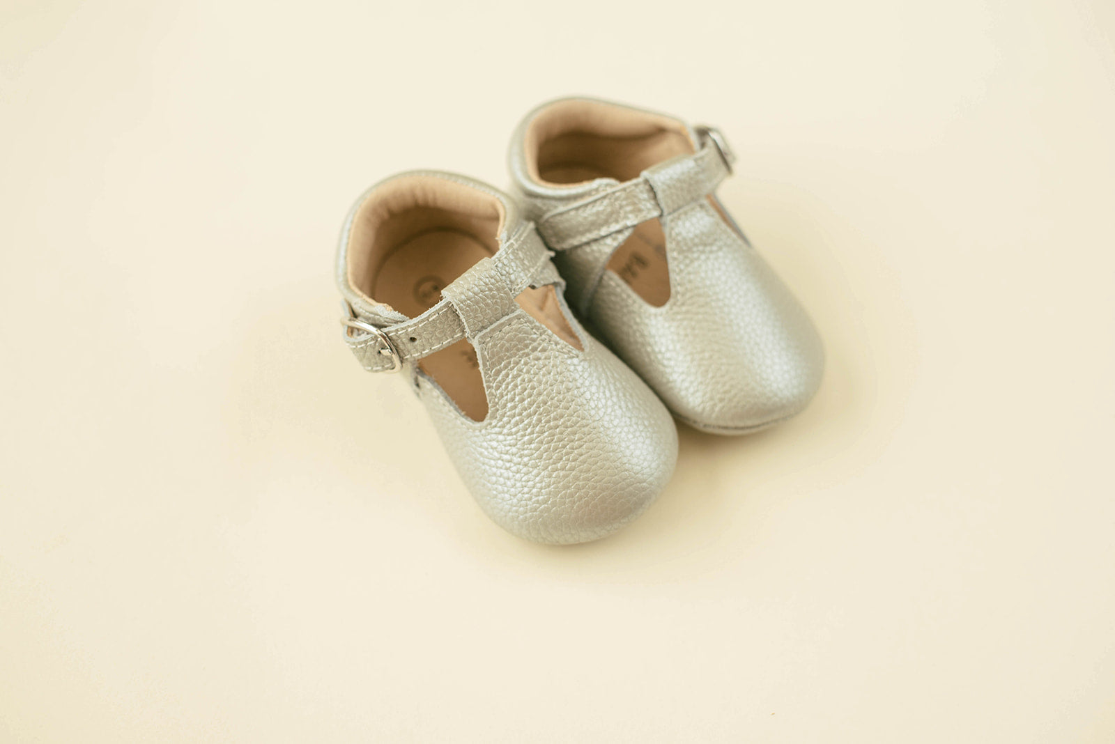 Soft-Sole Leather Mary Jane Moccasins in silver, featuring a t-strap buckle and soft leather soles for comfort.