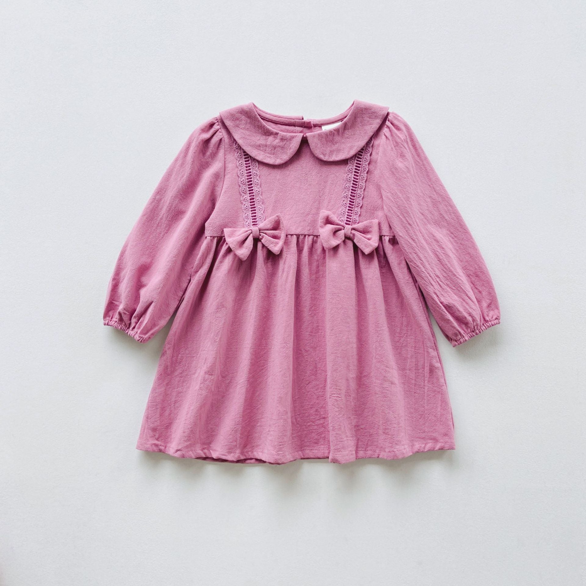 A stylish solid color dress for girls featuring mesh patches, available in pink and green, made from soft cotton material.