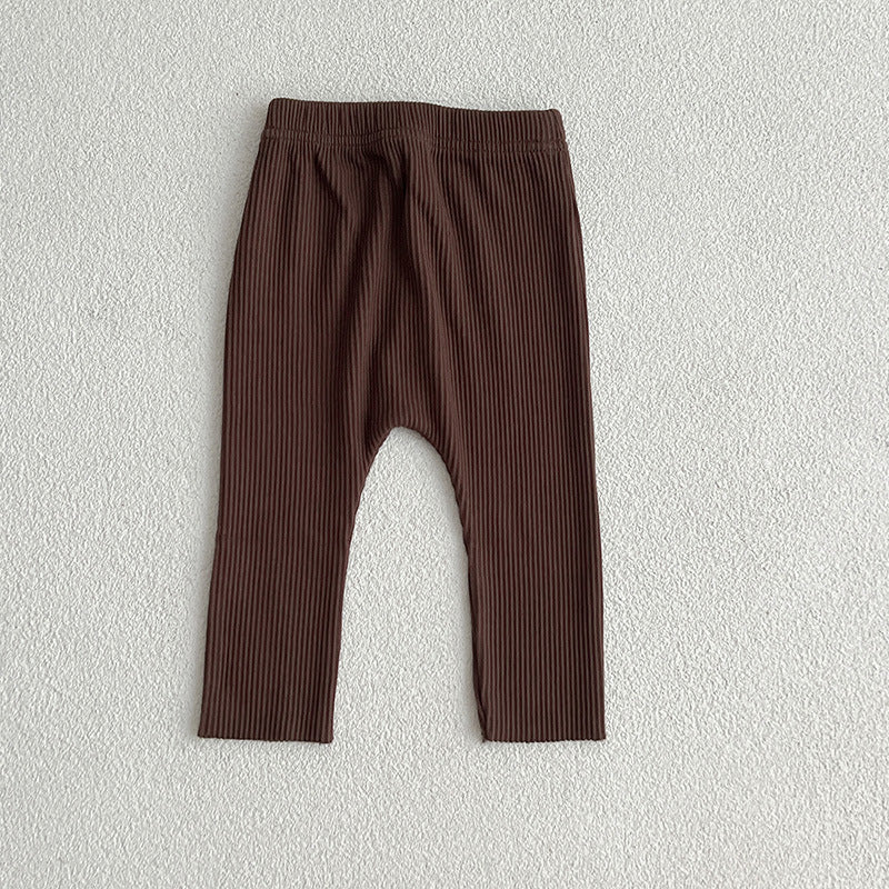 A pair of solid color soft cotton comfy leggings for baby girls, available in various colors including white, black, pink, blue, apricot, brown, and coffee.