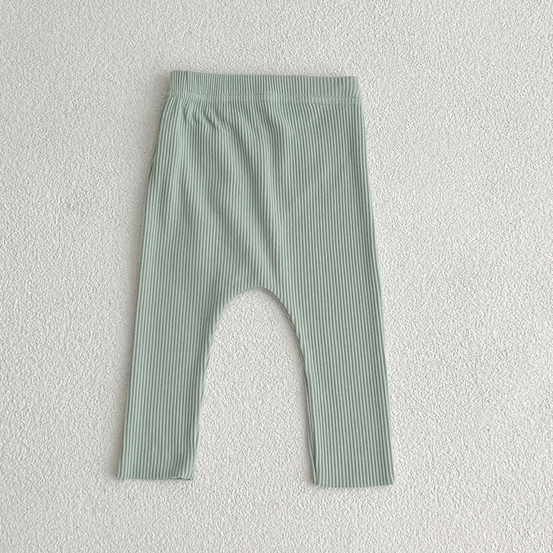 A pair of solid color soft cotton comfy leggings for baby girls, available in various colors including white, black, pink, blue, apricot, brown, and coffee.