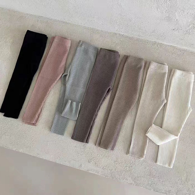 A pair of solid color soft cotton comfy leggings for baby girls, available in various colors including white, black, pink, blue, apricot, brown, and coffee.