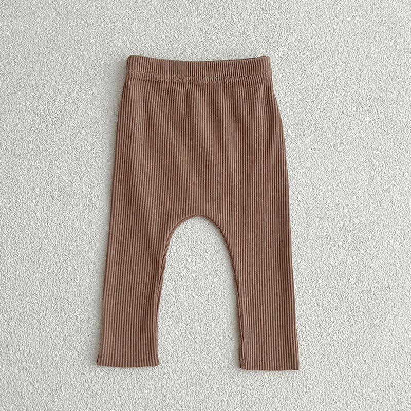 A pair of solid color soft cotton comfy leggings for baby girls, available in various colors including white, black, pink, blue, apricot, brown, and coffee.