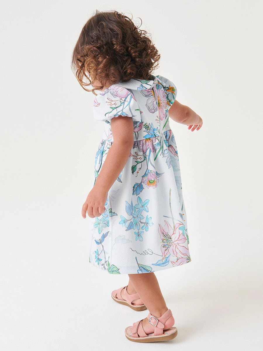 A beautiful white floral dress for baby girls featuring a Peter Pan collar and short sleeves, perfect for spring and summer wear.