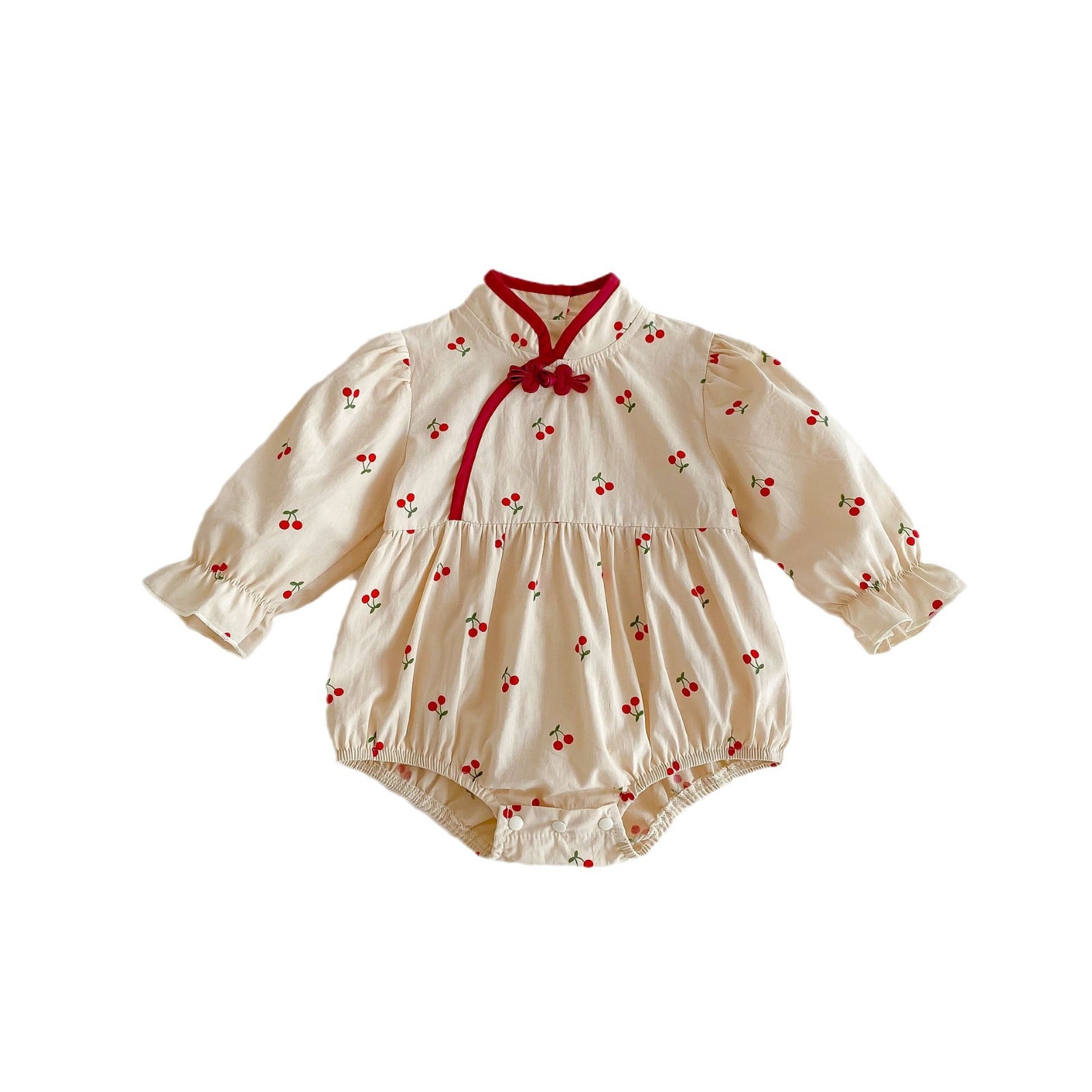 Baby girl wearing a cherry print long sleeves onesie in apricot color, showcasing a cute and stylish design.