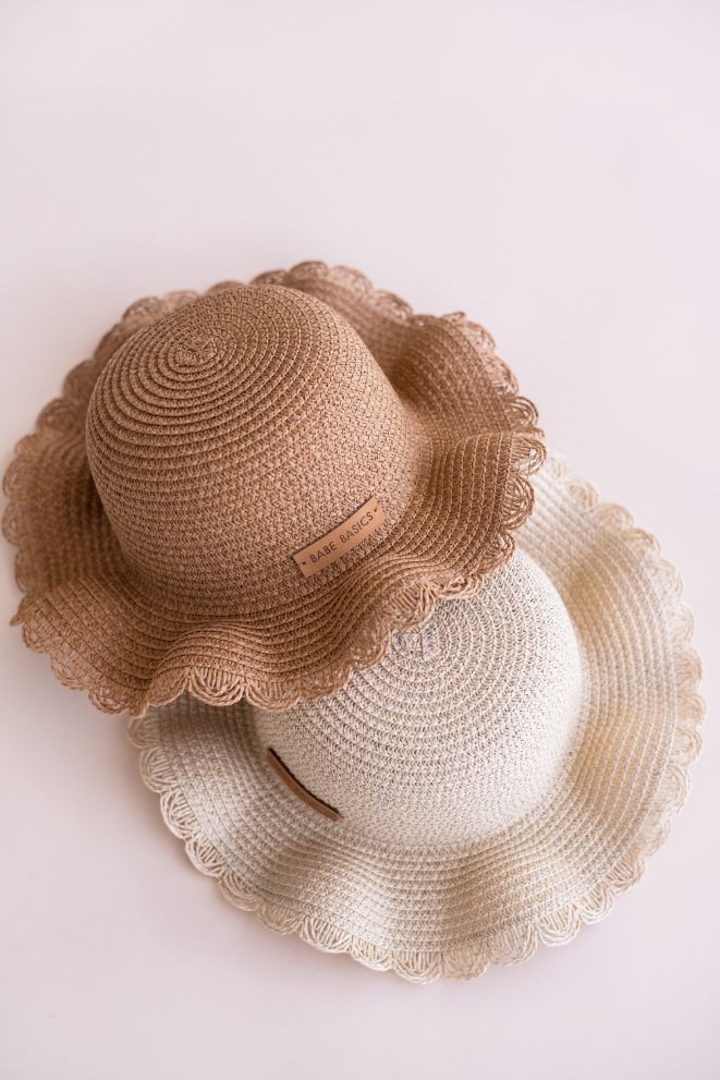 A stylish woven straw baby hat with an adjustable drawstring, perfect for sun protection during outdoor activities.