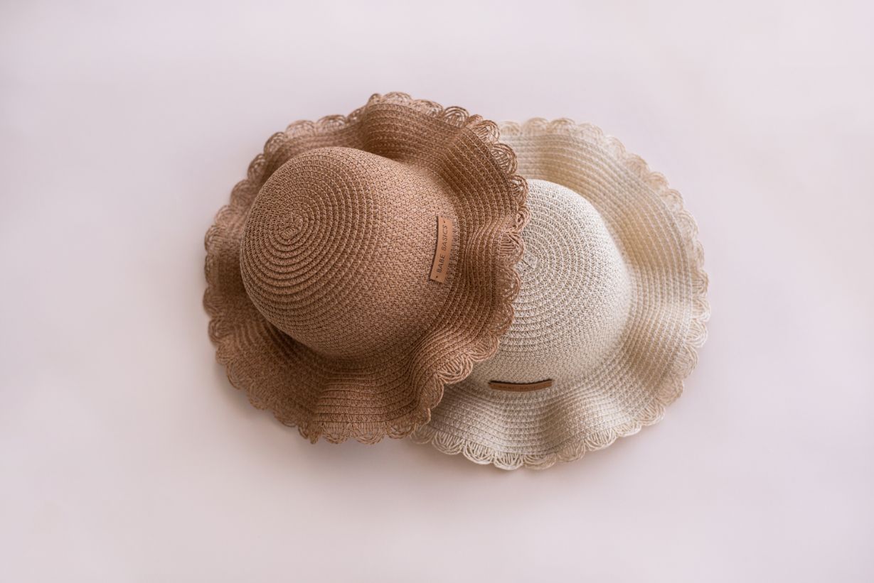 A stylish woven straw baby hat with an adjustable drawstring, perfect for sun protection during outdoor activities.