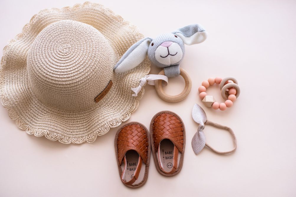 A stylish woven straw baby hat with an adjustable drawstring, perfect for sun protection during outdoor activities.