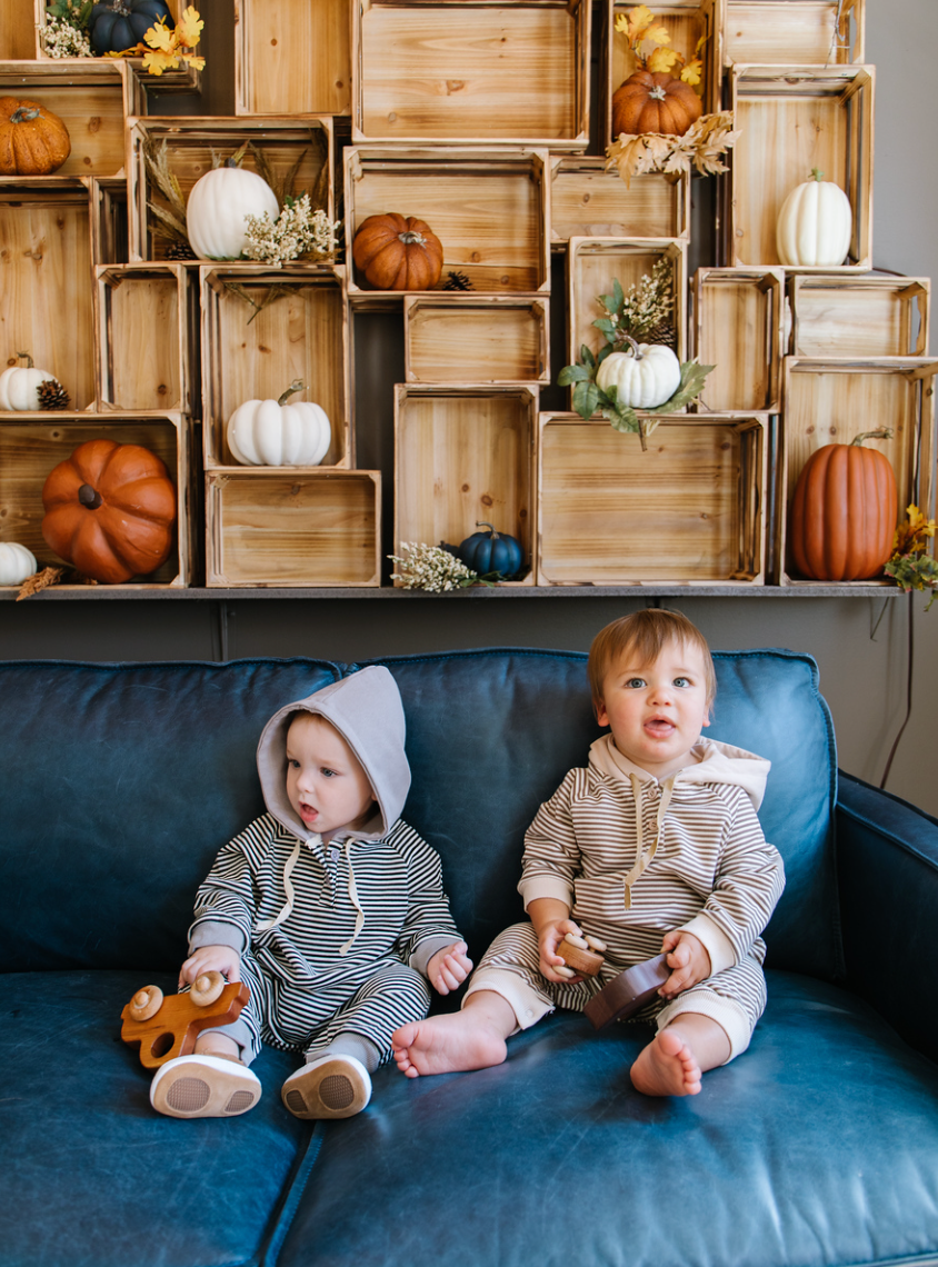 A cozy Hooded Striped Sweatshirt Jumpsuit for babies, featuring a trendy striped pattern and a convenient front zipper.