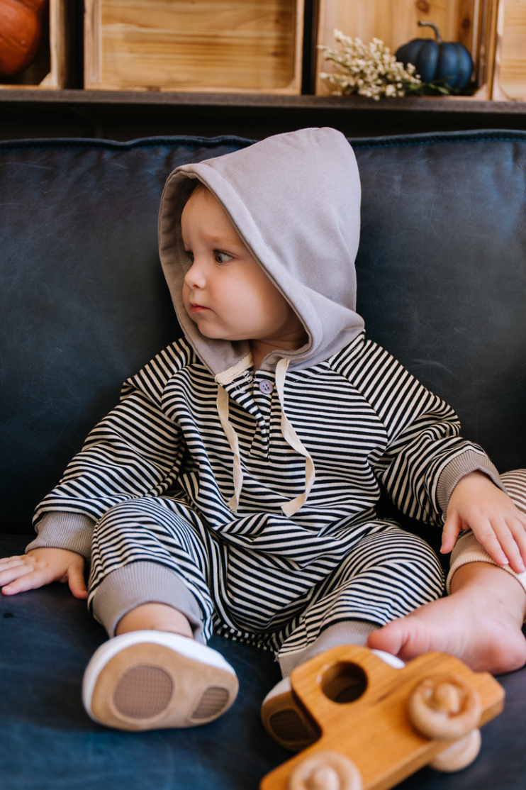 A cozy Hooded Striped Sweatshirt Jumpsuit for babies, featuring a trendy striped pattern and a convenient front zipper.