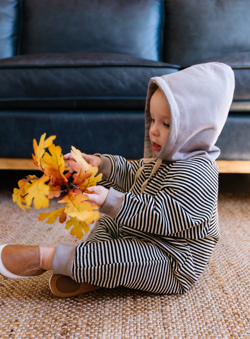 A cozy Hooded Striped Sweatshirt Jumpsuit for babies, featuring a trendy striped pattern and a convenient front zipper.