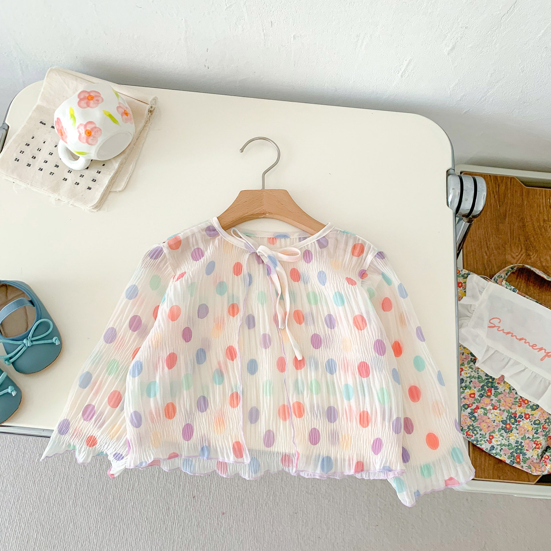 A summer outfit for baby girls featuring colorful polka dots on a beige background, made from breathable cotton.