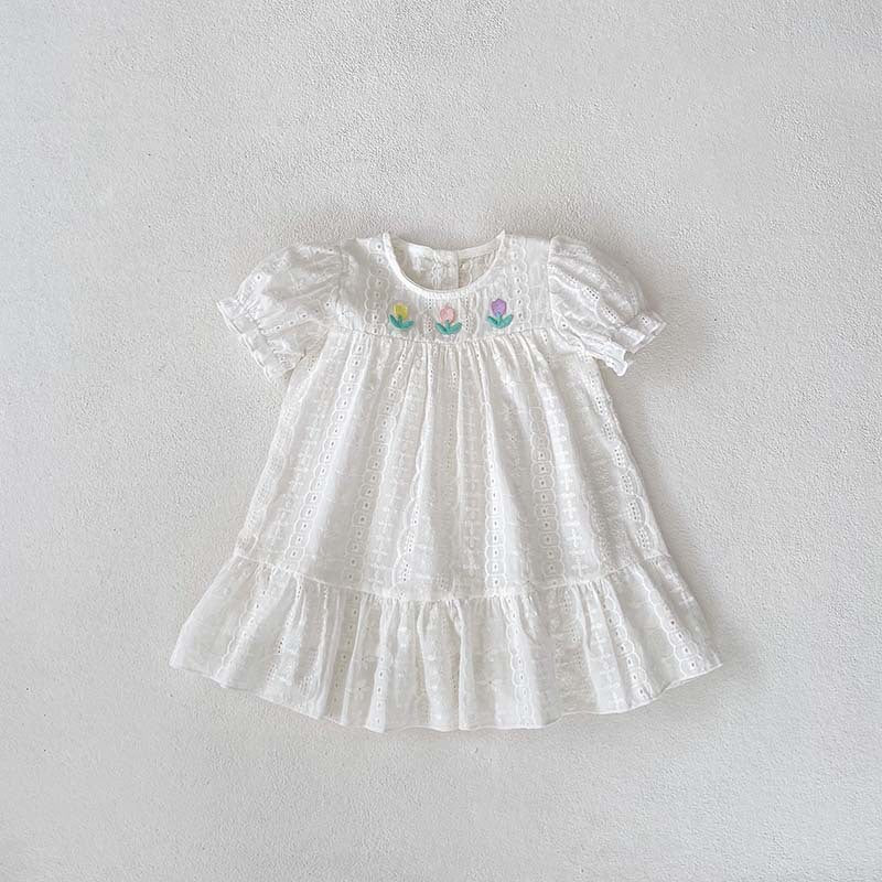 A cute summer dress for baby girls featuring floral embroidery and hollow-out short sleeves, made from soft cotton in white.