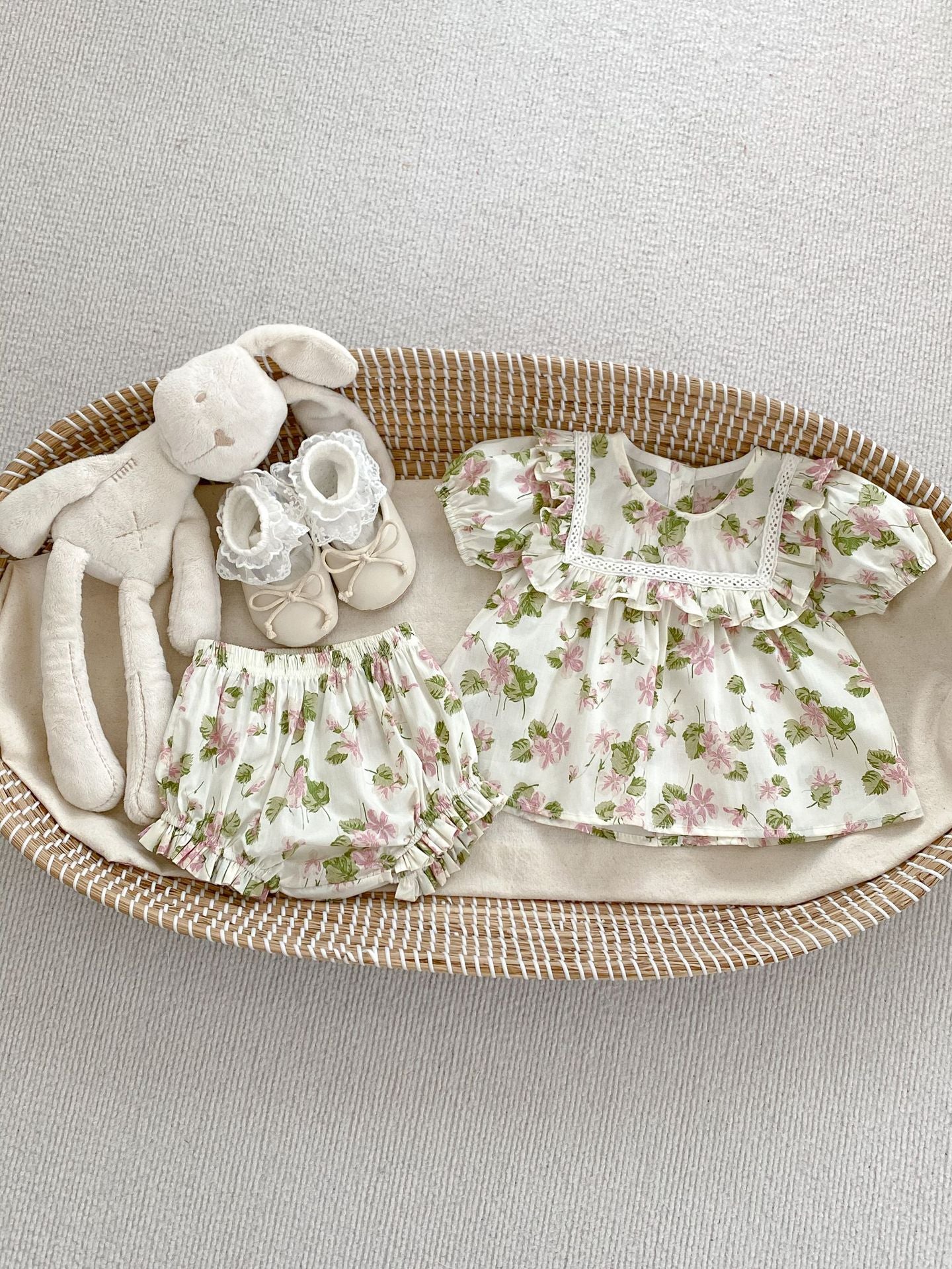 A cute summer dress for baby girls featuring a floral pattern, short sleeves, and available in multiple colors including black, pink, beige, and apricot.