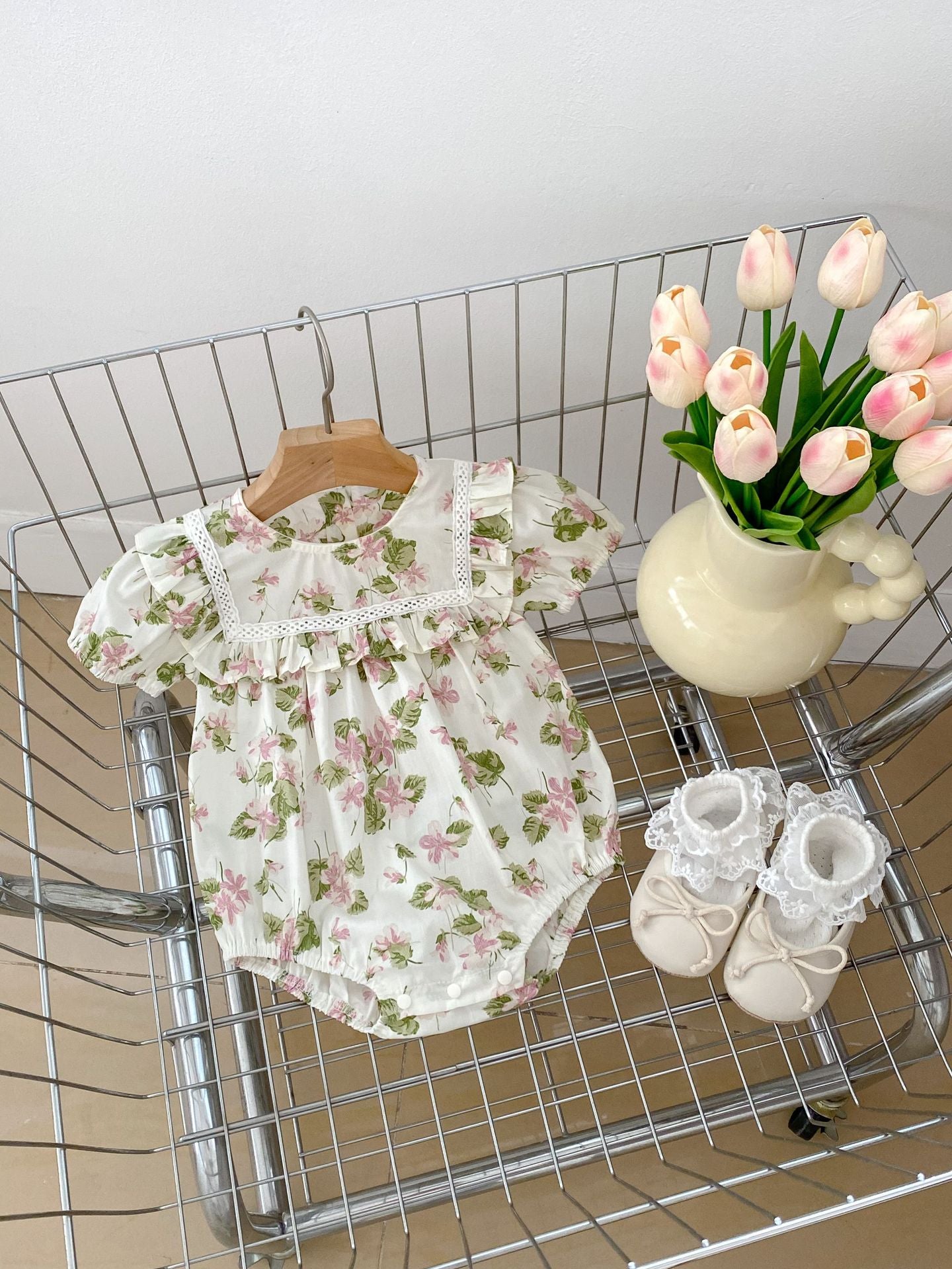 A cute summer dress for baby girls featuring a floral pattern, short sleeves, and available in multiple colors including black, pink, beige, and apricot.