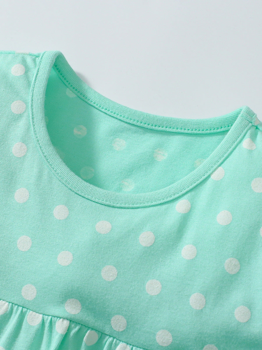 A vibrant green dress with polka dots for girls, paired with solid color shorts, perfect for summer outings.